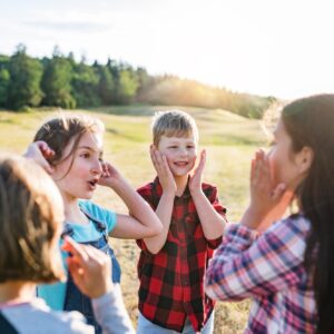 Group of school children standing on field trip in nature, playing