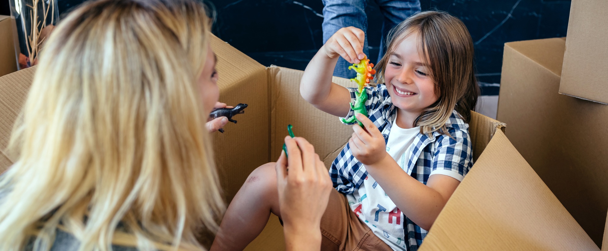 Mother and son playing inside a cardboard box