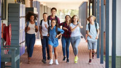 Teenager school kids running in high school hallway