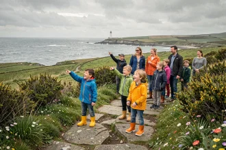 Famille avec enfants explorant un paysage côtier breton typique, avec falaises de granit, ajoncs et vue sur l'Atlantique